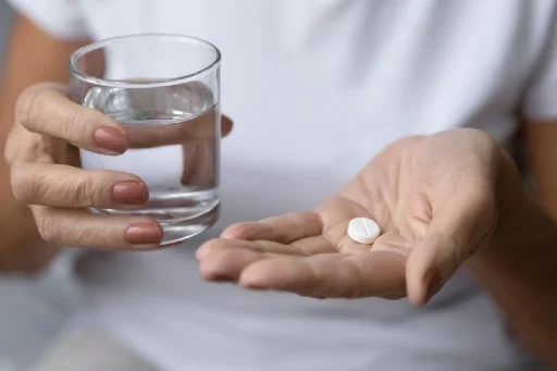 senior taking a medication with a glass of water