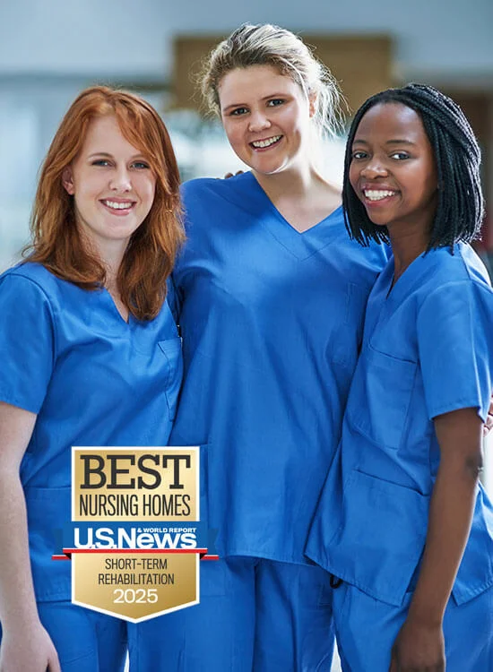 Three nurses smiling, wearing blue scrubs. U.S. News award: Best Nursing Homes 2025.