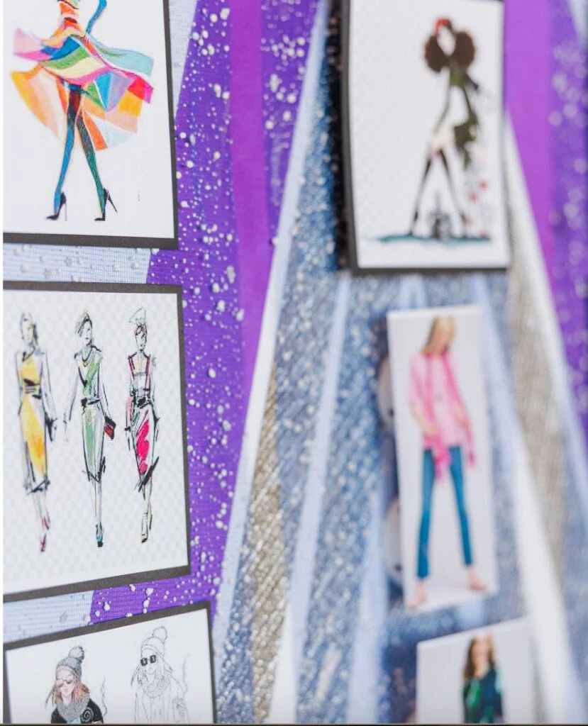 Fashion design sketches pinned on a textured board.