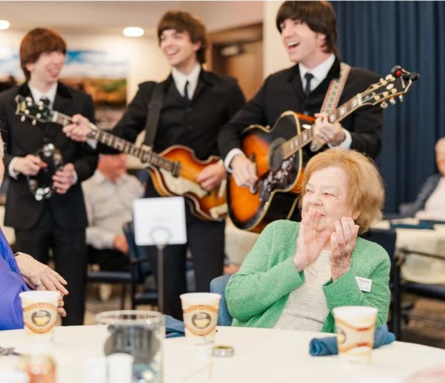 Musicians perform for a joyful group at a gathering.