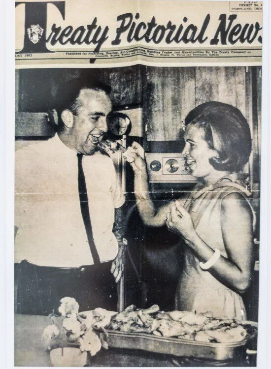 Man and woman eating together, smiling, in a vintage kitchen setting.