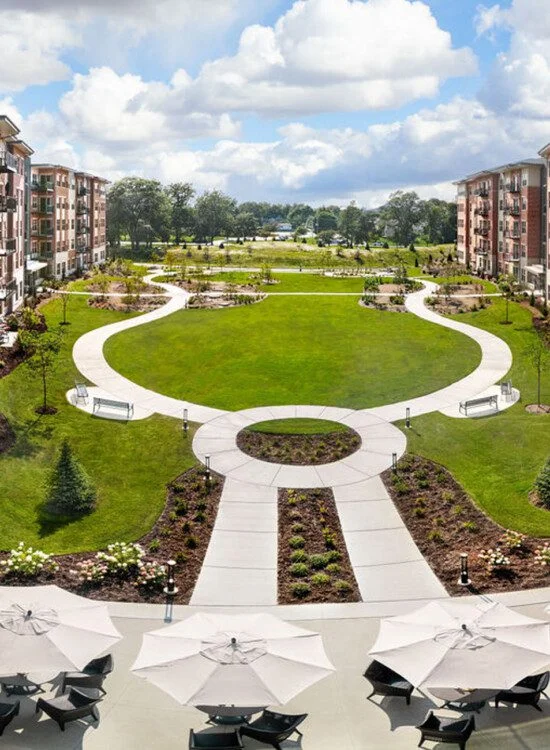 Courtyard of modern apartments with landscaped pathways and seating areas.