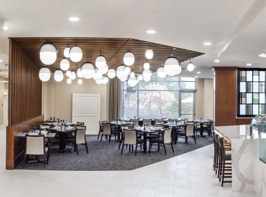 Elegant restaurant dining area with modern lighting and window views.