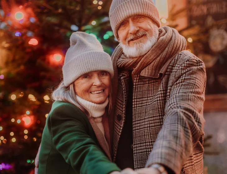 Happy senior couple enjoying christmas market.