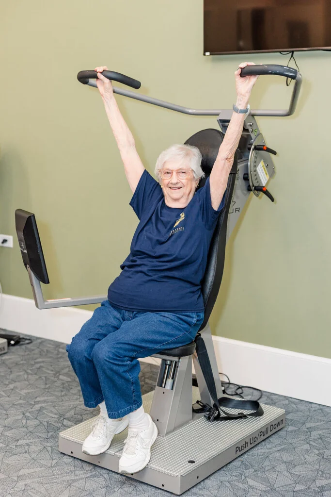 Oak Trace resident using strength training equipment in the fitness center