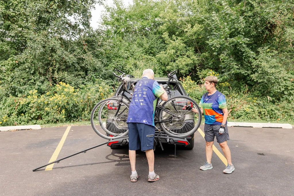 Chris Laperuto and Bill Roznowski loading their bikes onto a rack before a ride