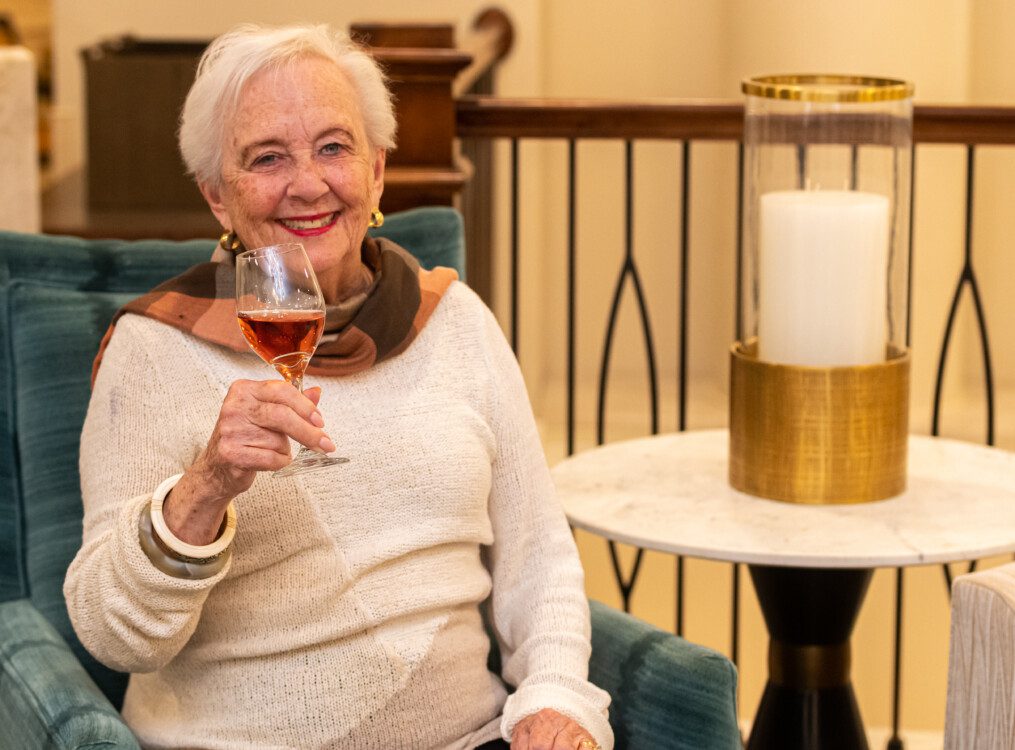 Senior woman holding up wine glass