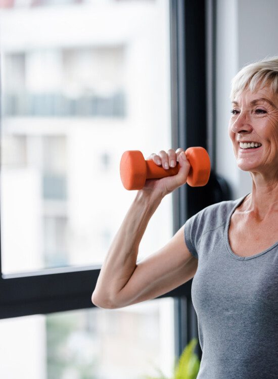 healthy senior woman uses dumbbells for strength training exercise