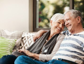 Shot of a happy senior couple relaxing together on a sofa outside at home senior couple snuggles on outdoor couch at their home