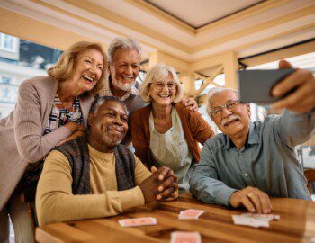 group of seniors take selfie together after playing a game of cards