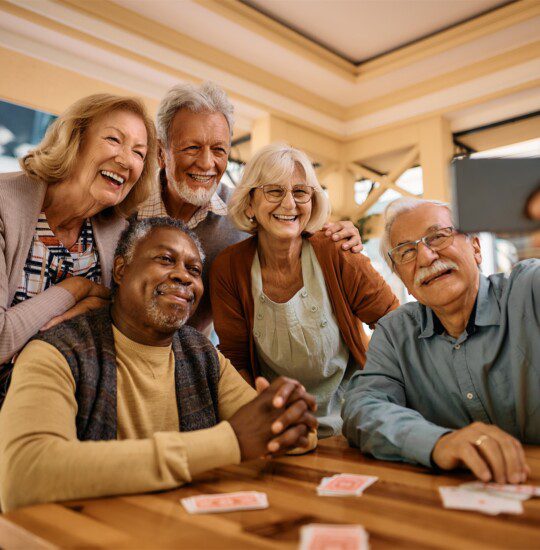 group of seniors take selfie together after playing a game of cards