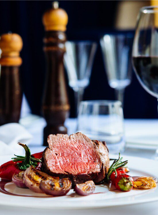 close-up of chef-created steak dinner and glass of wine