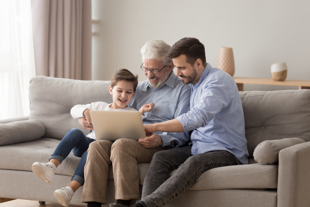 Senior man with son and grandchild taking a virtual tour of a senior living community