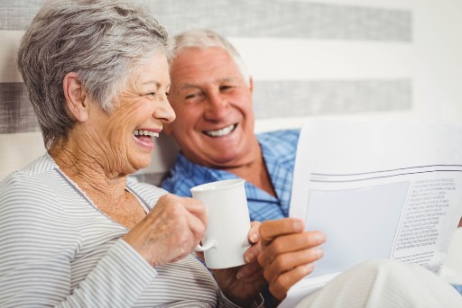 senior couple enjoying a cup of coffee while reading the newspaper