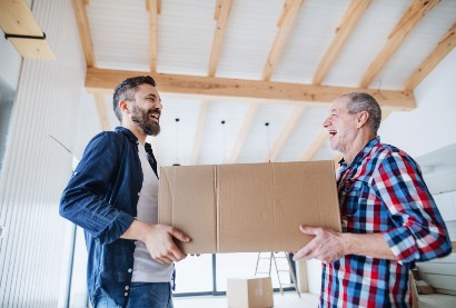 senior man and his son help to move him into a senior living community