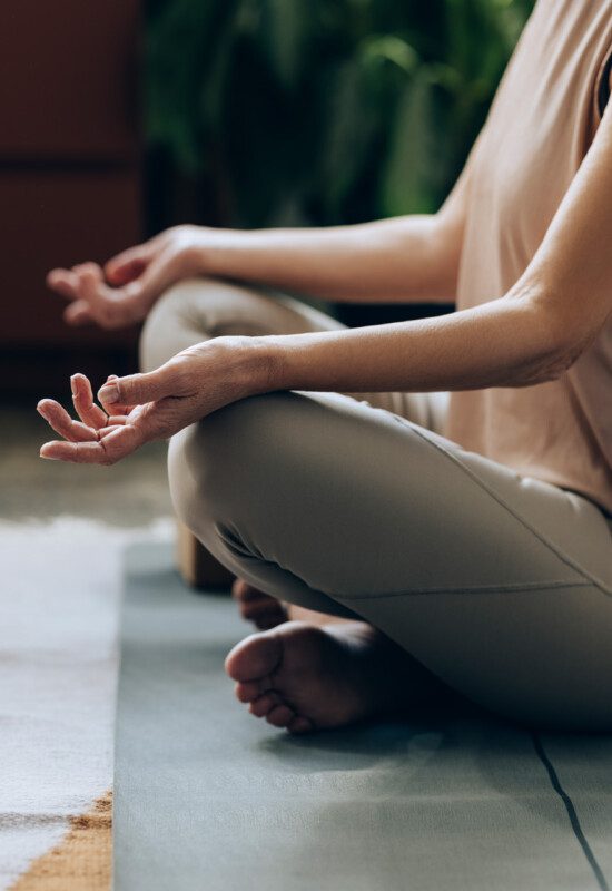 older woman sits and meditates during yoga