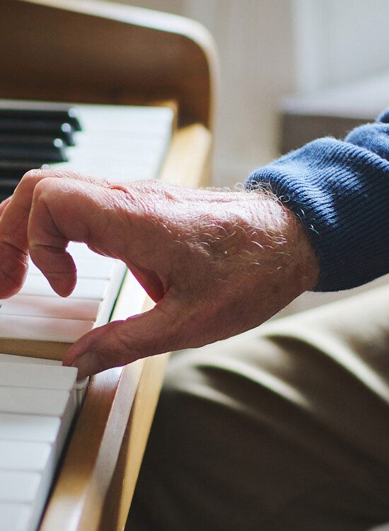 close-up of senior man playing the piano