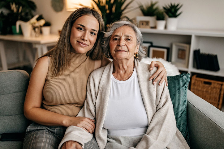 Adult woman sitting next to senior loved one