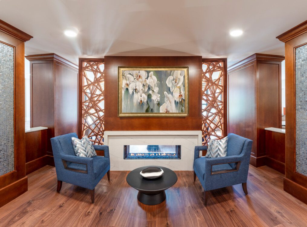 Small sitting area with chairs and glass fireplace at Oak Trace Senior Living Community