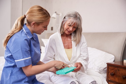 healthcare worker helping a senior with medication management
