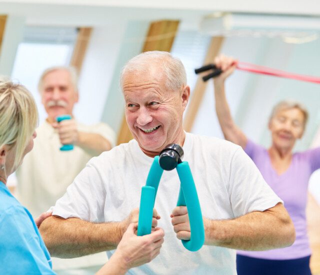 Senior man doing physical therapy exercises in a group class with others