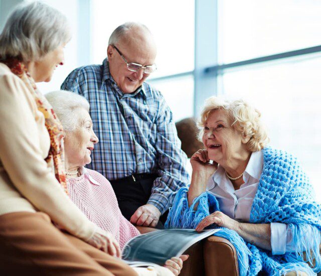 Group of four seniors smile and enjoy a chat