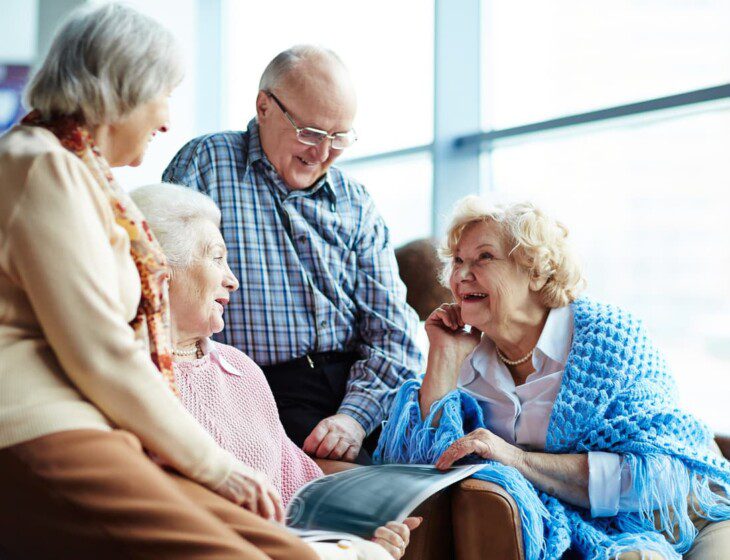 Group of four seniors smile and enjoy a chat