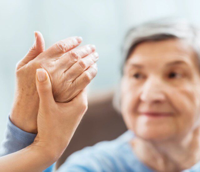 Senior woman receives hand therapy at Oak Trace Senior Living Community
