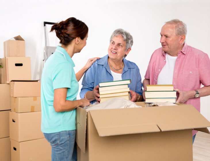 A senior couple receives help unpacking after a move to their senior apartment