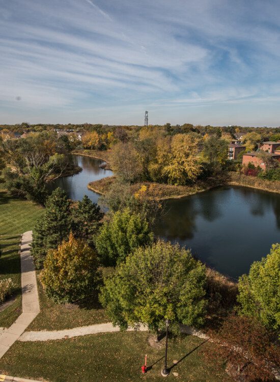 Aerial view of large body of water and walking paths at Oak Trace Senior Living Community
