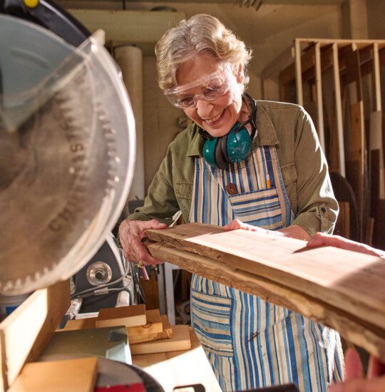 two senior women work together to complete a woodworking project