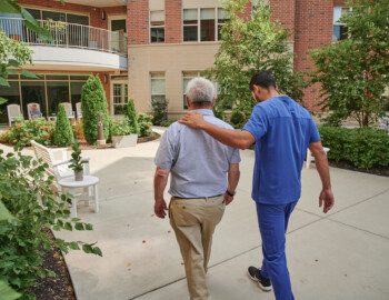 Shot 13 DanKucz KumailHussain ShuYing JessicaGilespie 0213 senior man walks and talks with caretake on scenic outdoor path