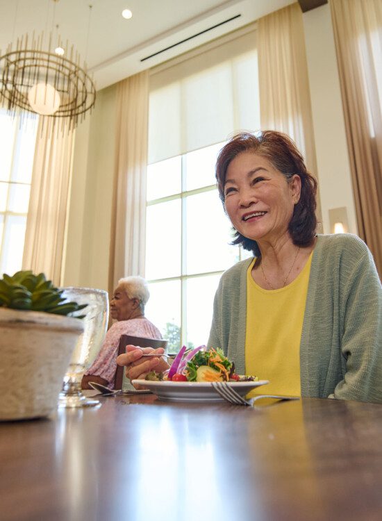 senior woman smiles and enjoys dinner with her companion