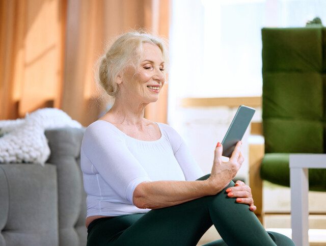 Older adult woman using a smartphone to connect with a friend.