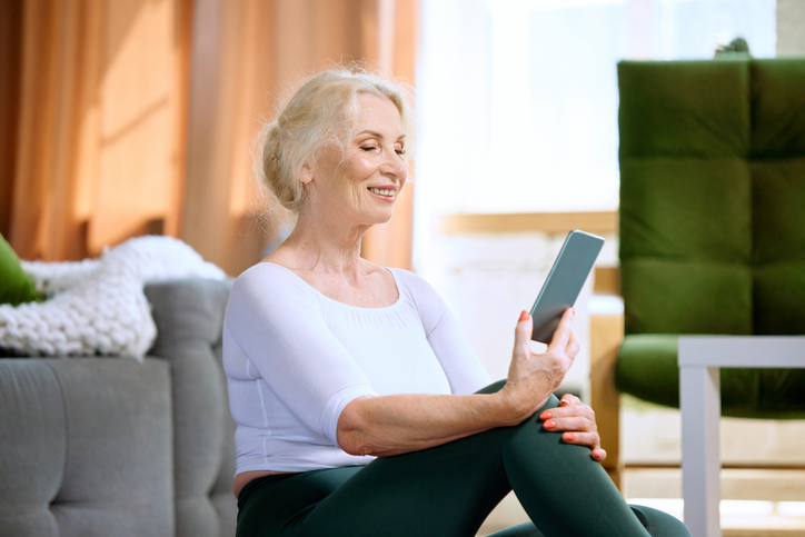 Older adult woman using a smartphone to connect with a friend.